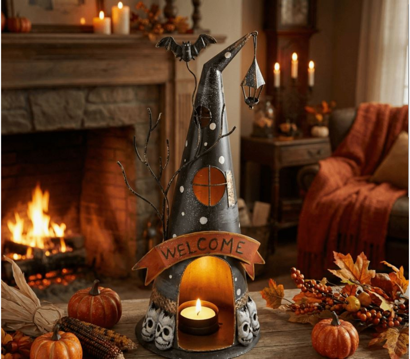 Halloween-themed decorative candle holder with a bat and 'Welcome' banner in front of a fireplace.