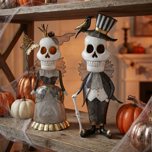 Decorative skeleton couple with pumpkins on a wooden surface