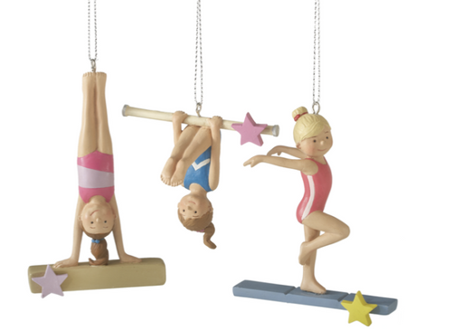 Three figurines of gymnasts performing on different apparatuses with stars around them.