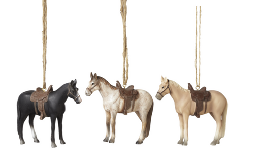 Three horse ornaments with saddles hanging on strings against a white background