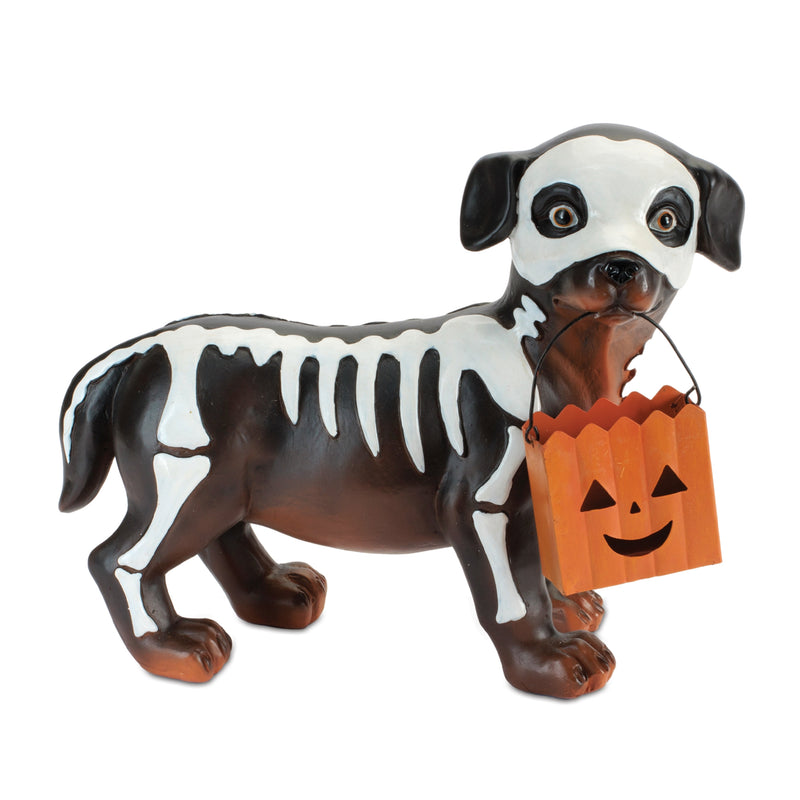 Dog figurine with skeleton design and Halloween pumpkin bucket on a white background