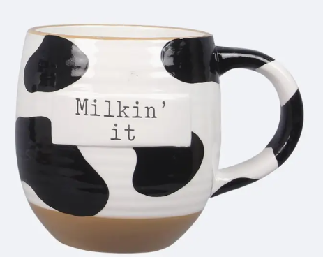 Cow print mug with 'Milkin' it' text on a white background
