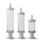 Three decorative glass cylinders with gray stone bases on a white background