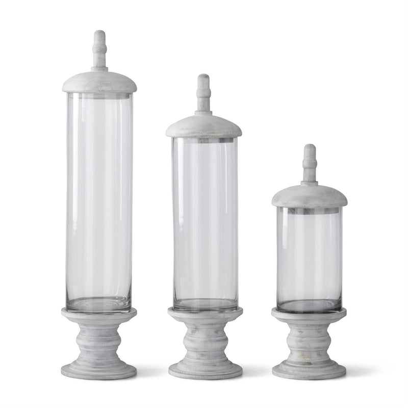 Three decorative glass cylinders with gray stone bases on a white background