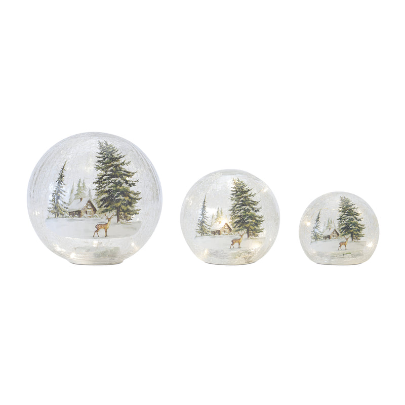 Set of three decorative glass spheres with Christmas scenes featuring trees and deer on a white background.