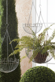 Decorative hanging planters with plants against a neutral background