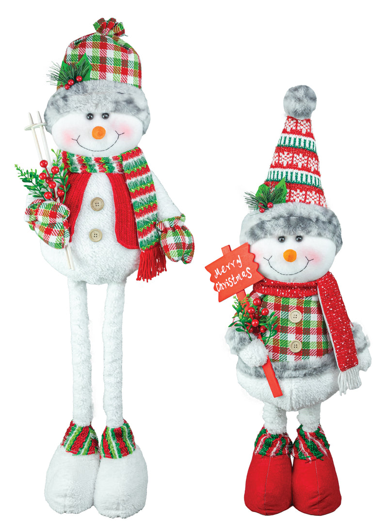 Two plush snowman Christmas decorations on a white background, one tall and one short, both wearing red and green plaid and holiday patterned hats, scarves, and boots, with one holding a 'Merry Christmas' sign.