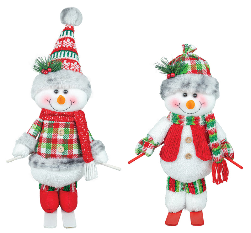 Two plush snowman Christmas decorations on a white background, one wearing a green and red plaid hat and scarf with red pants, and the other wearing a red knit hat and scarf with red pants.