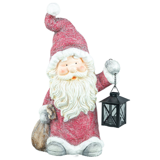 A festive Santa Claus figurine holding a black lantern and a sack, dressed in a glittery red coat and hat with a fluffy white beard and trim, set against a plain white background.