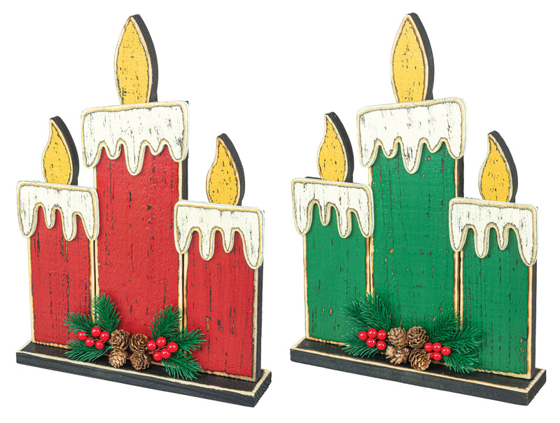 Two decorative wooden candle-shaped ornaments side by side, each with three candle shapes in red and green, white wax drips, gold flames, and pinecones and greenery at the base.