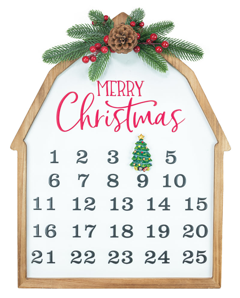 A house-shaped wooden advent calendar with a white face, gray numbers, pink 'Merry Christmas' lettering, a small green ornament, and pine branches with red berries at the top.