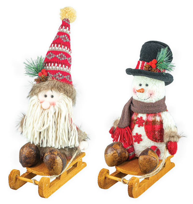 Two Christmas-themed decorative figures on wooden sleds against a white background: a gnome with a red and white striped knit hat, white yarn beard, and brown felt legs; and a snowman with a black top hat, red scarf, and brown felt legs.