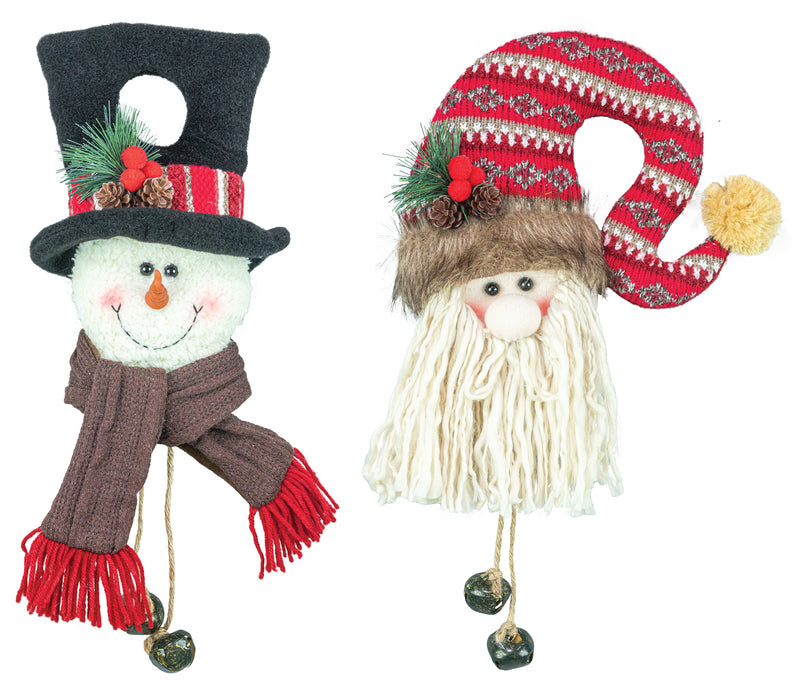 Two festive Christmas decorative figures on a plain white background: a snowman wearing a black top hat with red and white stripes, green pine accents, and a brown scarf with red fringe, and a Santa-style figure with a red patterned hat, white beard, brown faux-fur headband, and small bells hanging from the figures' hands.