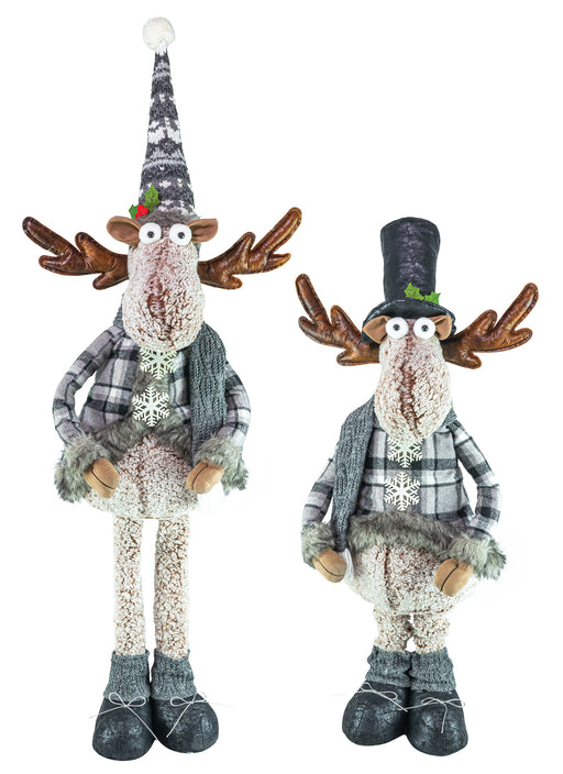 Two rustic Christmas reindeer figurines standing side by side on a plain white background. One reindeer wears a tall patterned hat and the other wears a tall black hat, both with plaid outfits, faux fur details, and knitted boots.