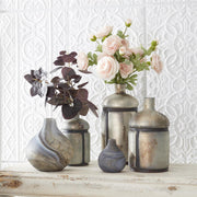 Decorative vases with flowers on a textured white wall background