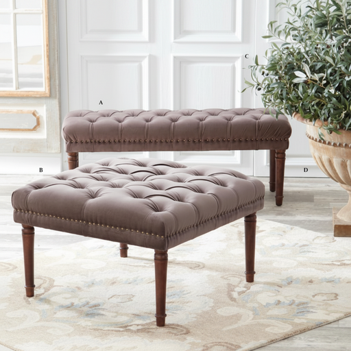 Brown tufted bench and ottoman set on a light wood floor with a plant in the background.