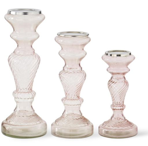 Three glass candle holders with textured design on a white background