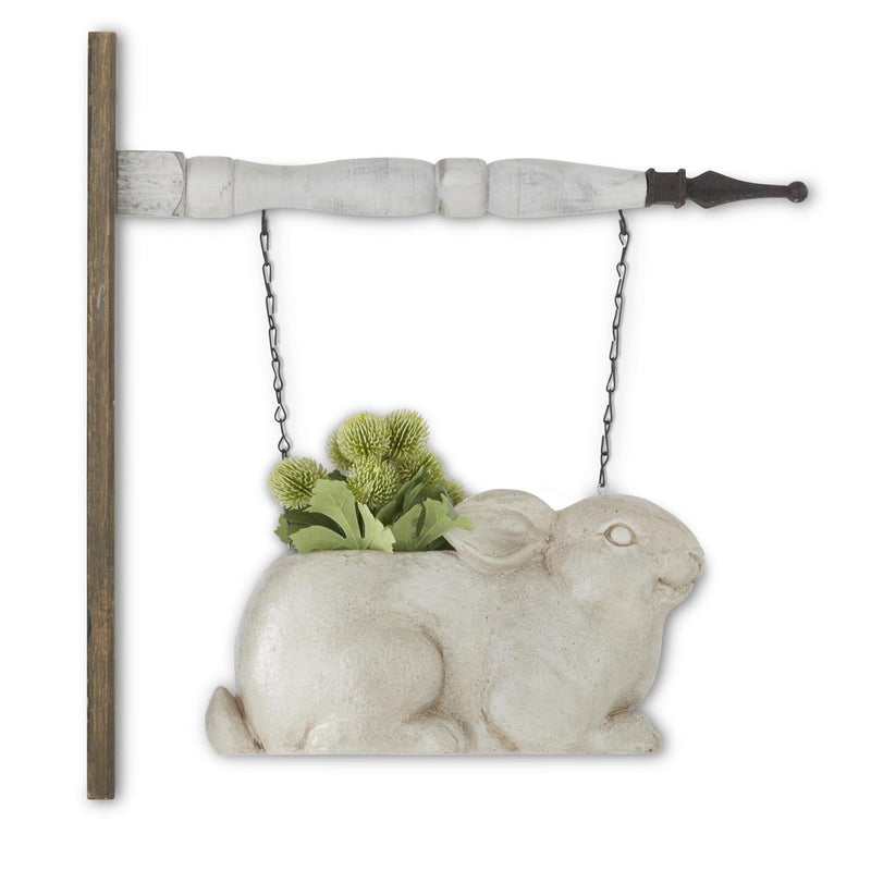 Decorative rabbit-shaped planter on a swing with greenery against a white background