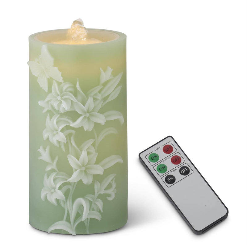 Decorative candle with floral design and remote control on a white background