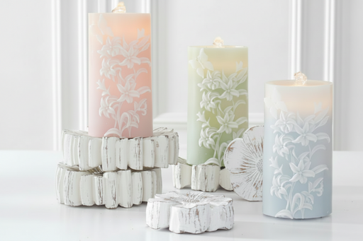 Decorative candles with floral patterns on a white surface