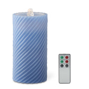 Blue striped candle with a remote control on a white background