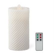 White textured candle with a remote control on a white background