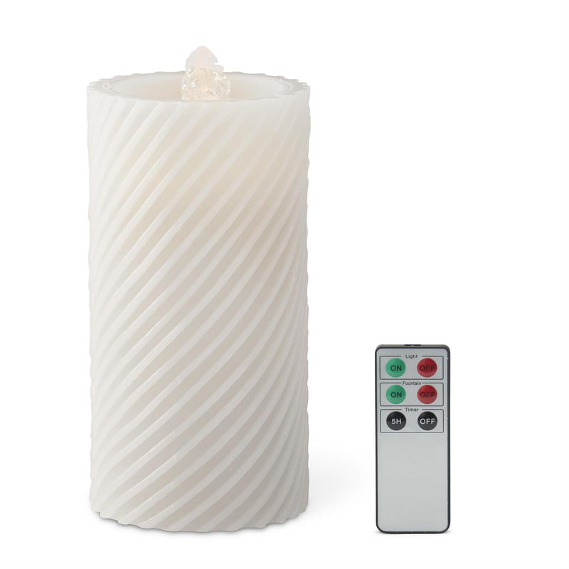 White textured candle with a remote control on a white background