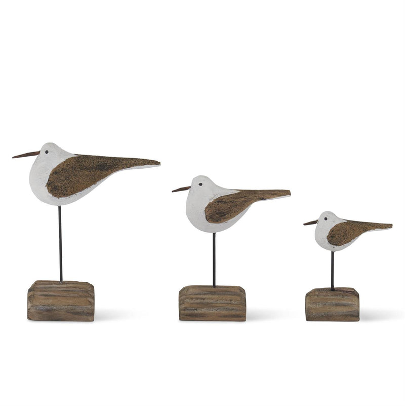 Three decorative bird figures on wooden stands against a white background