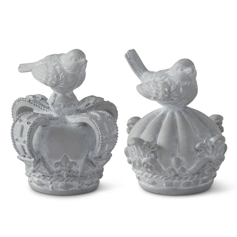Two decorative items shaped like crowns with bird figures on a white background