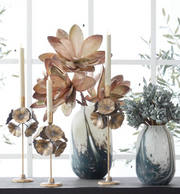 Decorative vases with floral designs and candles on a windowsill.