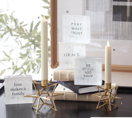 Decorative setup with candles, books, and motivational cards on a surface.