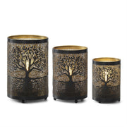 Three black metal candle holders with gold tree cutout designs, shown in sizes from left to right on a white background.