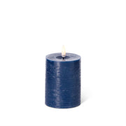 Blue candle with a white wick on a white background