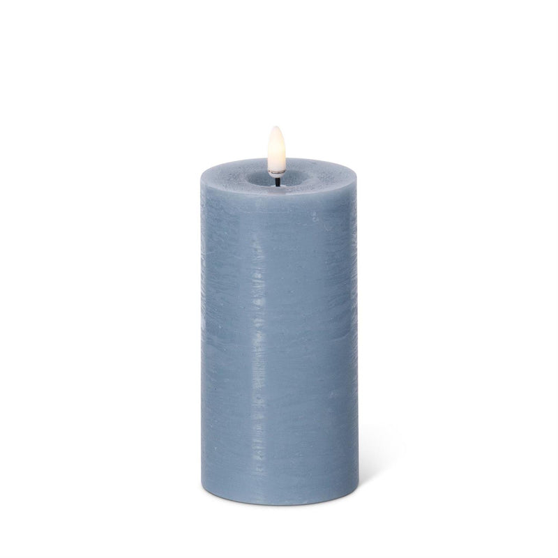 Blue candle with a white wick on a white background