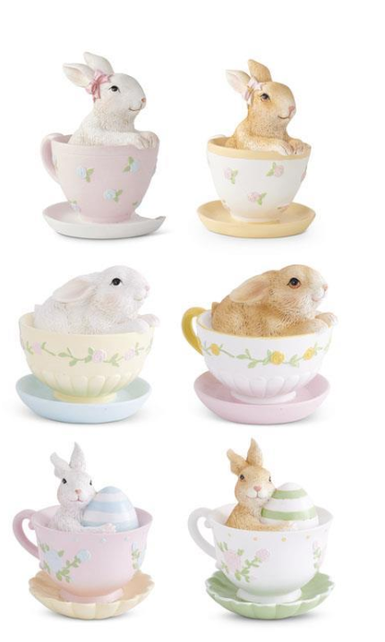 Set of rabbit figurines in teacups on a white background