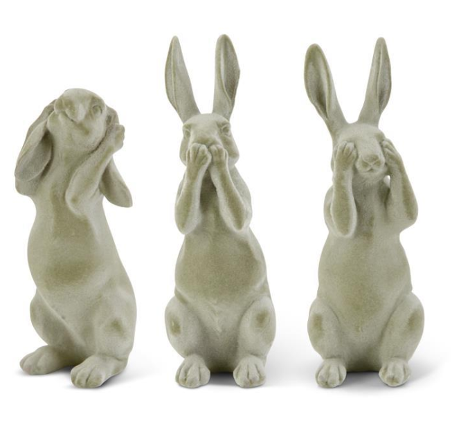 Three stone rabbit statues with different poses on a white background
