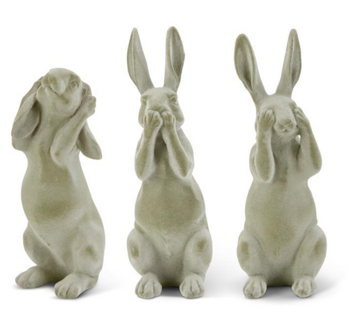Three stone rabbit statues with different poses on a white background
