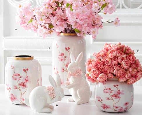 Decorative vases and rabbit figurines with floral designs on a white surface.