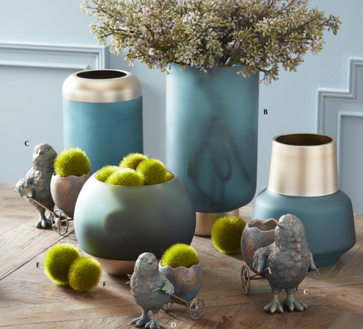 Decorative vases and bird figurines on a wooden surface with a light blue wall background.