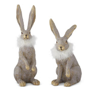 Two decorative rabbit statues with fur on a white background