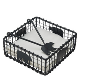 Black wire basket with decorative cut-out shapes on a white background