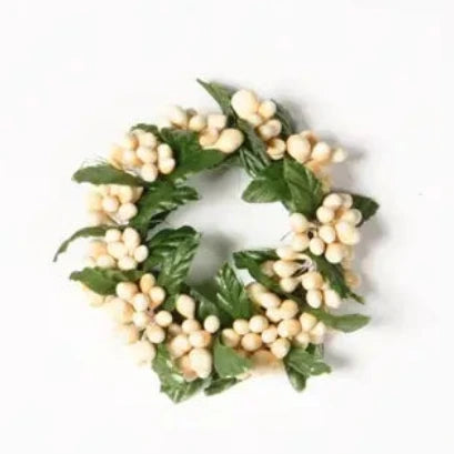 Small wreath with white berries and green leaves on a white background