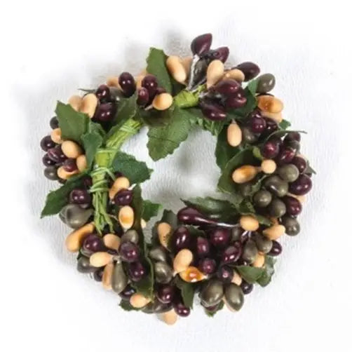 Decorative wreath with green leaves, purple berries, and beige cones on a white background
