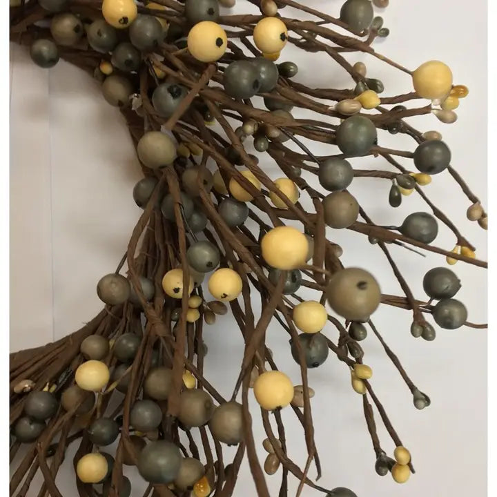 Faux berry branch wreath decoration with brown twig branches and round berries in muted gray-green and pale cream tones, shown against a plain light background.