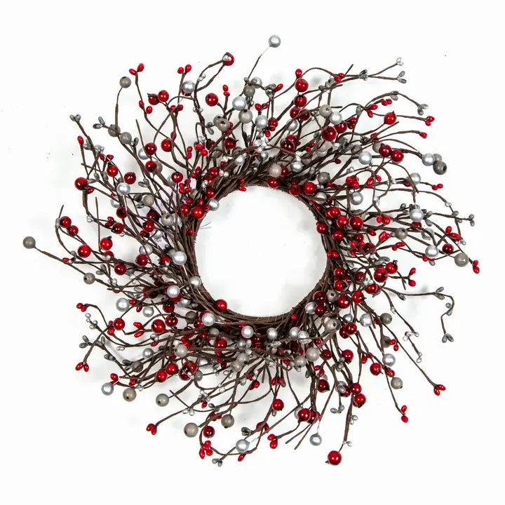 A festive Christmas wreath featuring a dark brown twig-style circular base densely decorated with small red berries and metallic silver berry accents, photographed against a solid white background.