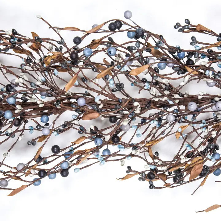 A decorative garland of brown twig branches with faux blue, black, white, and tan berries, arranged on a plain white background.