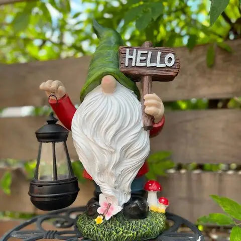 Gnome figurine holding a 'Hello' sign and a lantern outdoors