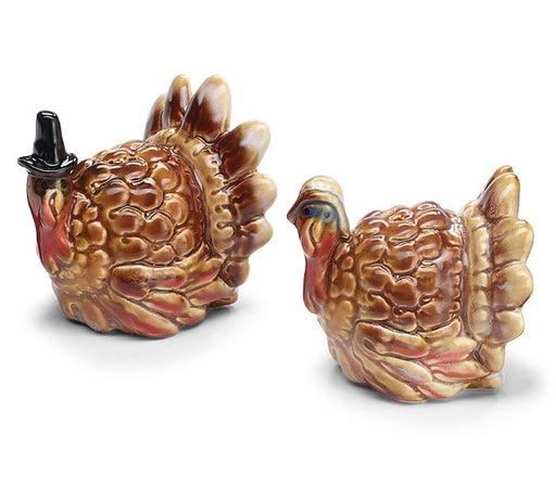 Two ceramic salt and pepper shakers shaped like turkeys, one wearing a small black top hat, on a white background.
