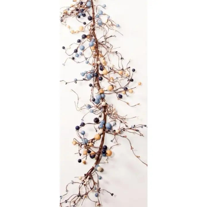 A decorative garland featuring natural brown branches adorned with small blue, navy, beige, and white berries, shown against a plain white background.
