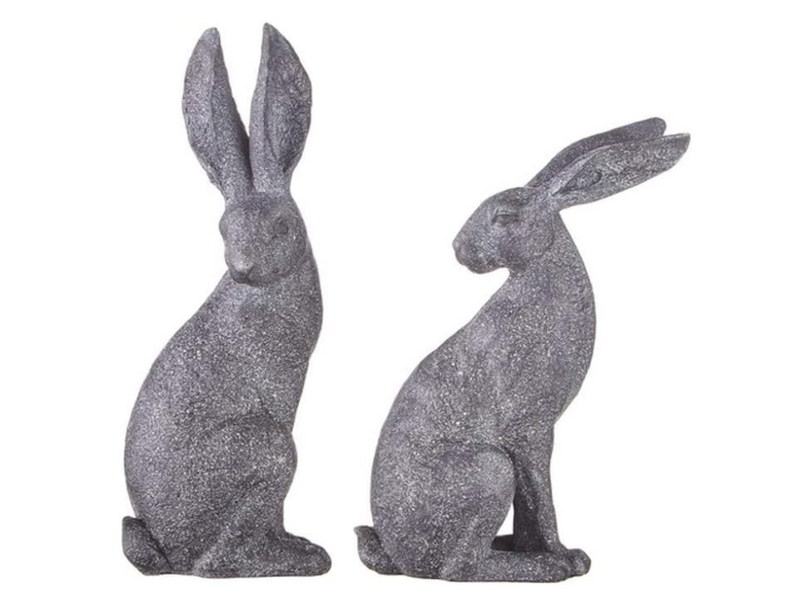 Two gray glittery rabbit statues on a white background